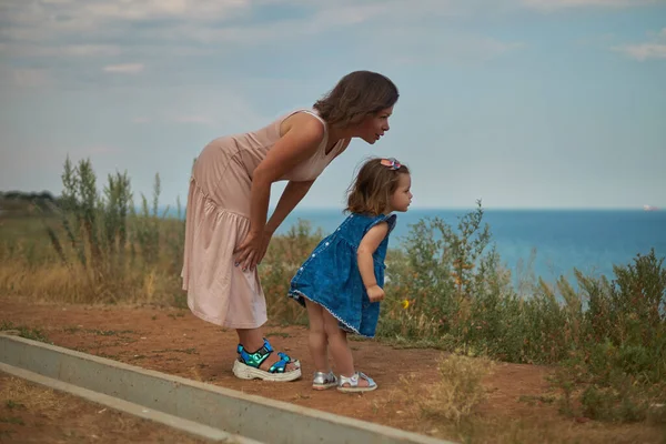 Mother leaned over to her daughter and talks about something — Stock Photo, Image