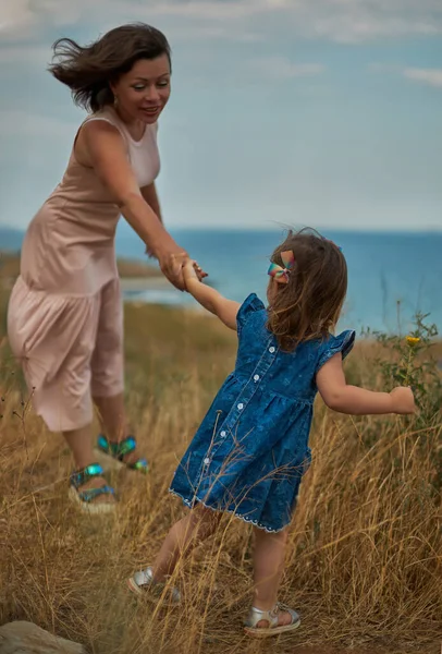 De dochter houdt haar moeder bij de hand en leidt haar — Stockfoto