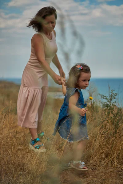 De dochter houdt haar moeder bij de hand en leidt haar — Stockfoto