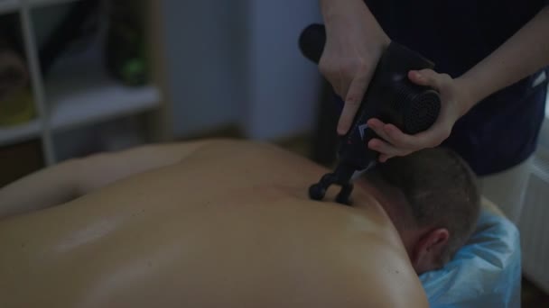 Close-up mężczyzna masaż terapeuta robi masaż pleców do człowieka w pokoju masażu z przyćmionymi światłami Low key — Wideo stockowe