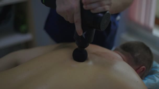 Close-up mężczyzna masaż terapeuta robi masaż pleców do człowieka w pokoju masażu z przyćmionymi światłami Low key — Wideo stockowe