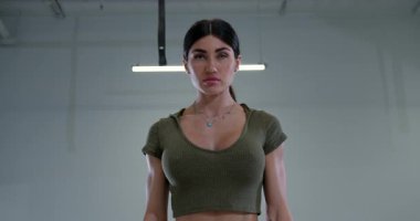 Atletik kadın, dambılın üzerine eğilmiş ters sineği infaz ediyor. Egzersiz sırasında belini ve omuzlarını güçlendirirken vücuduna odaklanıyor..