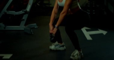 Gevşek saçlı genç bir kadın, iyi donanımlı bir salıncakta sallanıyor ve gücünü ve formda olduğunu gösteriyor. Çevre enerjik ve motive edicidir..