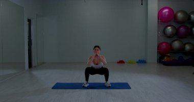 Sportif kız fitness kulübünün iç kısımlarında alt vücut kaslarını çalıştırıyor.
