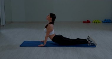 Esmer, formda kadın kasları Yoga Mat Jimnastik Stüdyosu Egzersiz sırasında geriyor