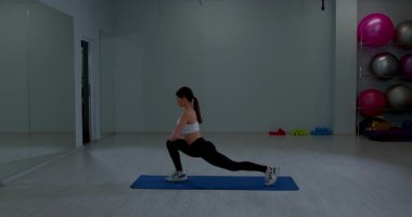 Geniş Jimnastik Stüdyosunda Mat 'in Bacaklarını Esneten Odaklı Sporcu Kadın Hareketleri