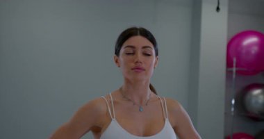 Sakin kadın farkındalık egzersizi yapıyor. Üstü başı bembeyaz, sağIık gevşeme anı giyiyor.