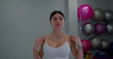 Beyaz kadın sporcu modern spor merkezinde antrenman için hazırlanıyor.