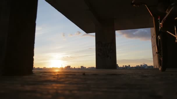 Een bmx rijder gaan trugh zon — Stockvideo