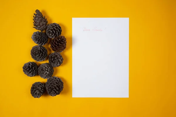 Carta de los niños a Santa para Navidad sobre fondo amarillo con conos de pino —  Fotos de Stock
