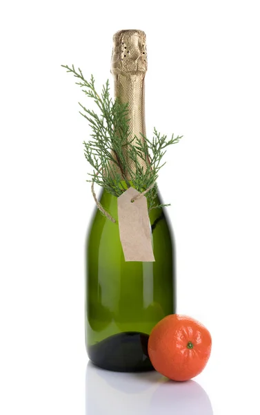 Vánoční alkoholické pozadí s lahví šampaňského zdobené jehličnatou větví a mandarinkou na lehkém pozadí. — Stock fotografie