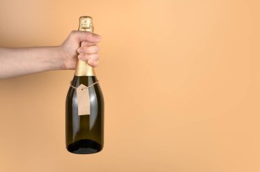 Noel arkaplanında turuncu arka planda bir kadının elinde şampanyayla.