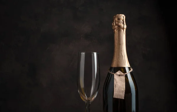 Láhev alkoholu a sklenice vína na hnědém pozadí s prostorem pro kopírování. — Stock fotografie
