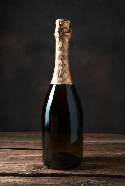 Fondo alcohólico, champán sin etiqueta sobre un fondo de madera atmosférico. — Foto de Stock