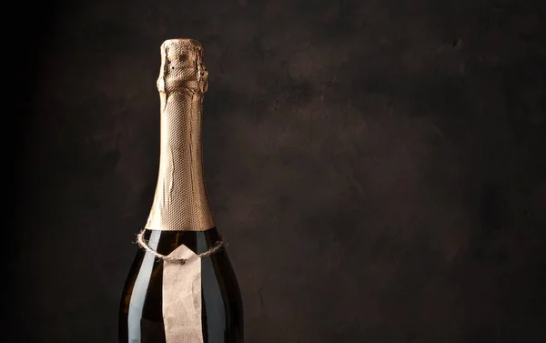 Andar de uma garrafa de champanhe em um fundo de concreto marrom. — Fotografia de Stock