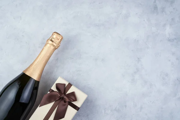 Composição festiva com uma garrafa de champanhe e uma caixa de presente. — Fotografia de Stock