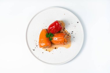 Pilavlı üç dolma biber ve arka planda kıyma..