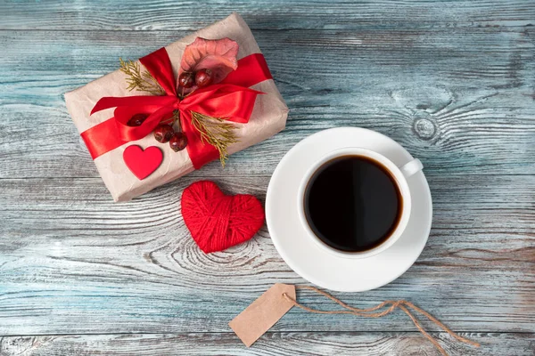 A Cup of coffee and a gift with a heart on February 14. Top view with space to copy. — Stock Photo, Image