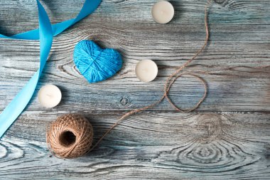 14 Şubat 'ın arkaplanı, mavi renkli bir kalp, mum ve kurdele..