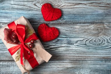 İki kırmızı kalp ve ahşap bir arka planda hediye..