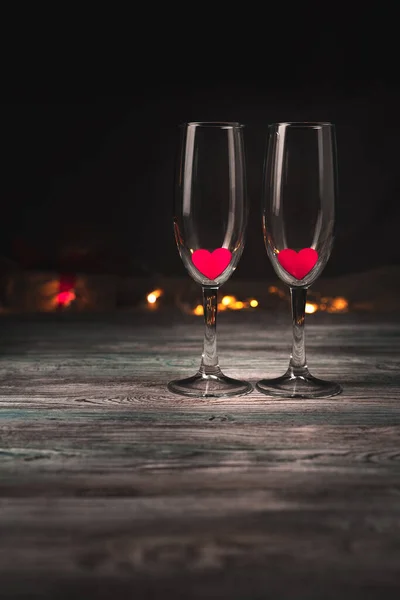 Vasos de vino vacíos con corazones rojos sobre un fondo marrón. —  Fotos de Stock