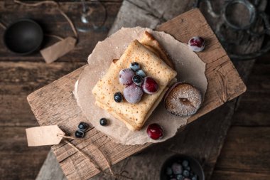 Atmosferik arka planda donmuş böğürtlenli krep yığını.