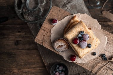 Ahşap tezgahta böğürtlenli kızarmış krep..