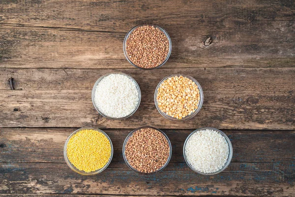 Different cereals on a wooden background. Top view, with space to copy. — Stock Photo, Image