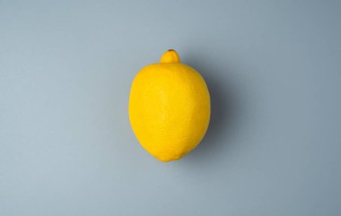 Gri arka planda olgun bir limon. Kopyalamak için en üstteki görünüm. Yararlı ürünler kavramı.