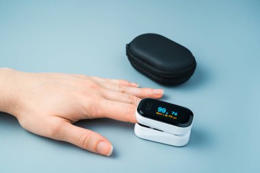 Oksijen seviyesinin, bir insanın elindeki bir oksimetre ile ölçülmesi.