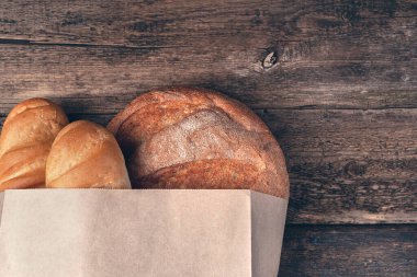 Ahşap arka planda taze, kabuklu ekmek. Yukarıdan görünüşü.