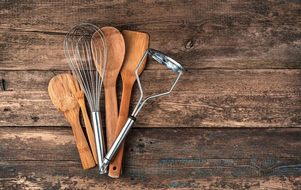 Un conjunto de accesorios de cocina sobre un fondo de madera. — Foto de Stock