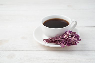 Beyaz arka planda kahve ve çiçeklerle narin bir şenlik ortamı. Yan görünüm.
