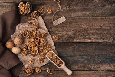 Soyulmuş ceviz ve ahşap bir arka planda kabuk. Kopyalamak için boşluk olan üst görünüm.