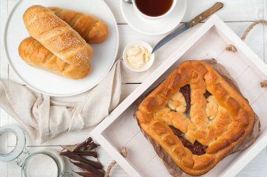 Hafif arka planda meyveli kek ve taze ekmek ruloları..