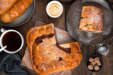 Elmalı turta, taze ekmek ve kahverengi ahşap arka planda çay..