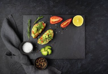 İki avokado sandviçi, domates, limon ve biberiye....