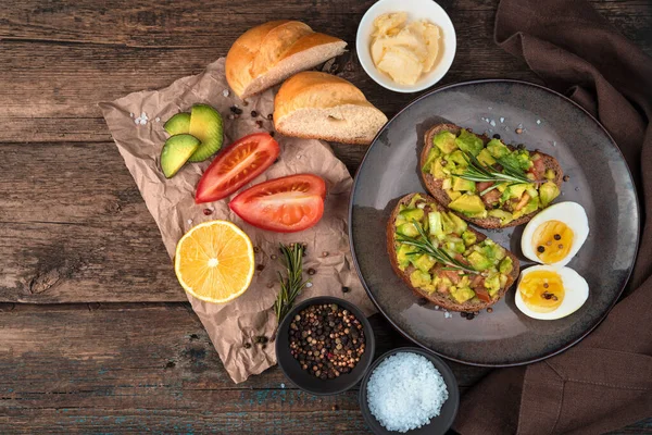 Завтрак с бутербродами с авокадо на деревянном фоне. — стоковое фото