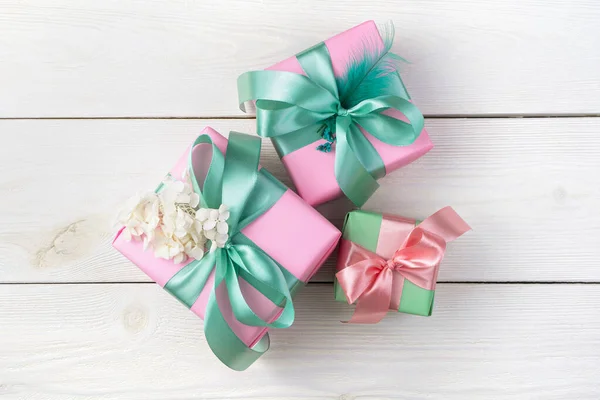 Cajas de regalo rosadas con cintas sobre fondo de madera blanca. Vista superior, con espacio para copiar. —  Fotos de Stock