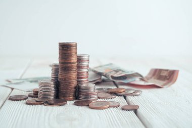 Arka planda büyüteçteki bozuk para yığınları. Kopyalama alanı olan yan görünüm.