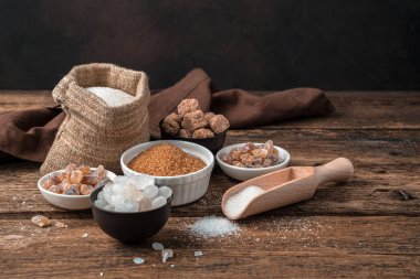 Tahta arka planda beyaz ve kamış şekeri. Kopyalama alanı olan yan görünüm.