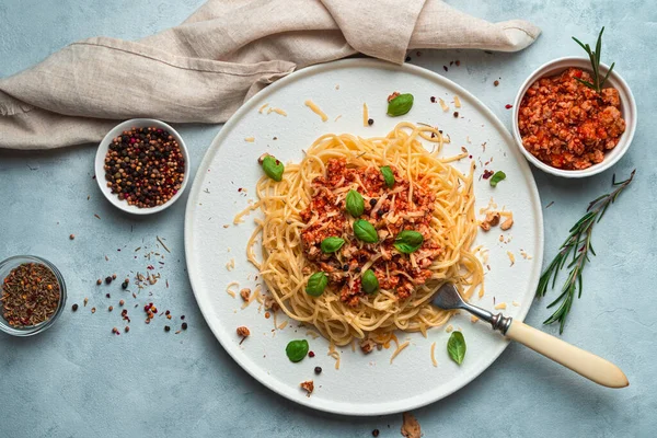 青みがかった背景にスパゲティと肉ボロネーゼソースのおいしい料理. — ストック写真