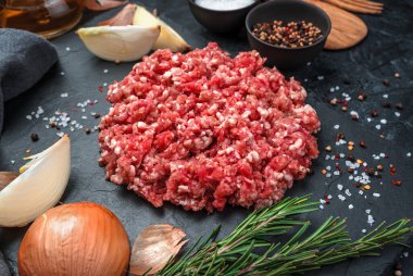 Siyah arka planda soğanlı ve biberiyeli kıymalı hindi eti..