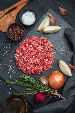 Siyah arka planda doğranmış taze domuz eti. Mutfak arka planı, dikey yönelim.