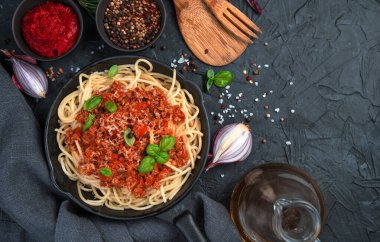 Siyah beton arka planda spagetti ve makarna bolonez.