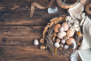 Ahşap arka planda bıldırcın ve tavuk yumurtaları olan şenlikli bir arka plan..