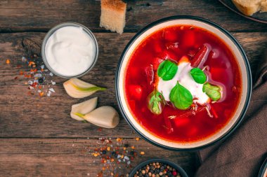 Ekşi kremalı ve fesleğenli borscht, ahşap kahverengi arka planda. Kopyalama alanı olan üst görünüm.