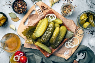 Siyah arka planda soğan ve baharatlı ev yapımı salatalık turşusu..