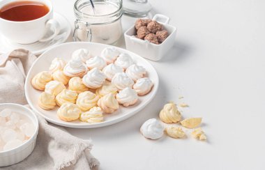 Bir fincan çay ve kamış şekerinin arka planında limon ve beyaz krema. Kopyalama alanı olan yan görünüm.