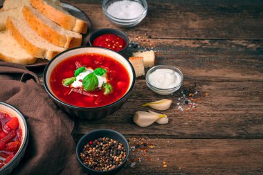 Borscht ile öğle yemeği, ekşi krema ve doğal ahşap arka planda sarımsak. Geleneksel tarifler kavramı.